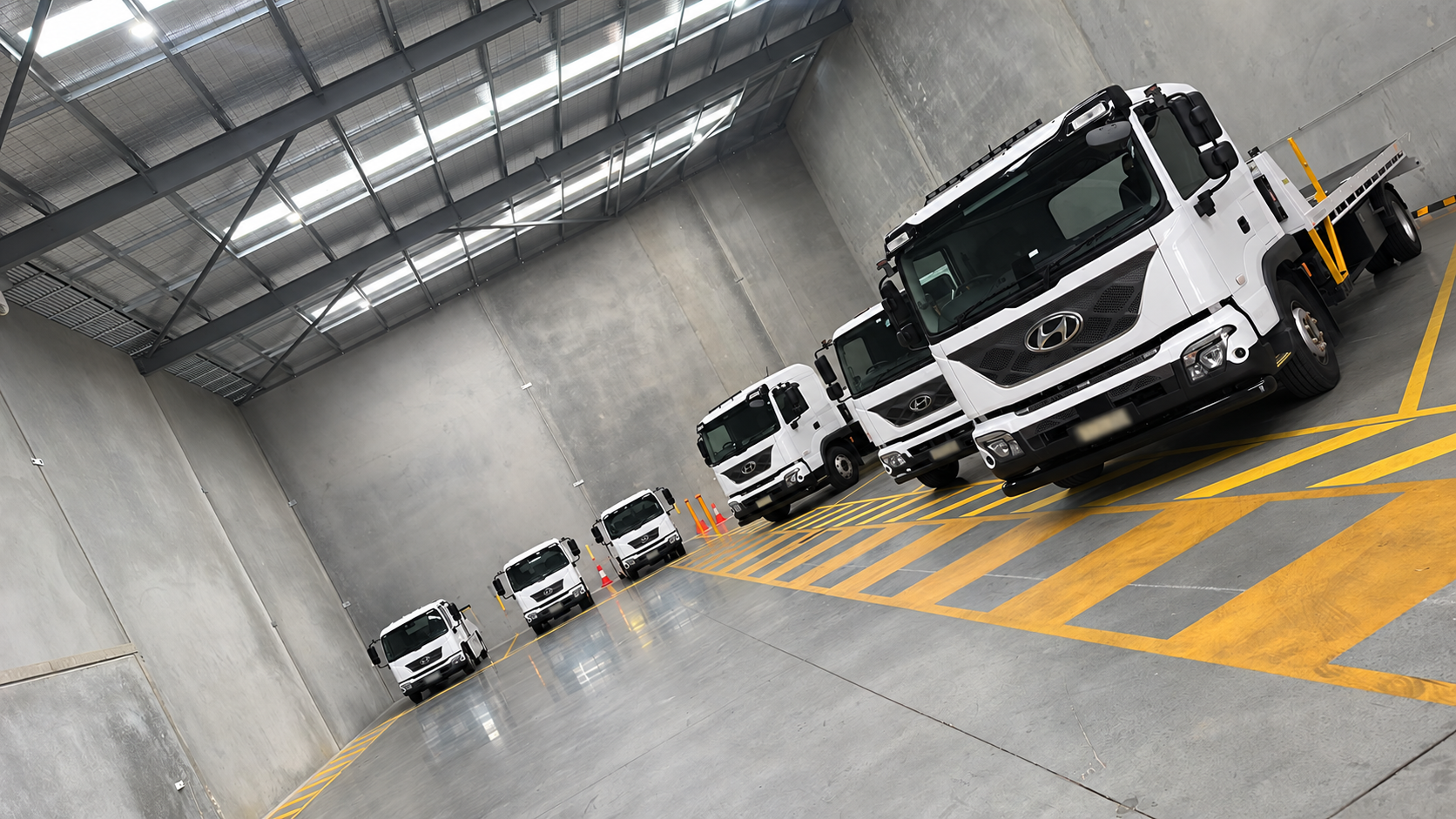 Line of plain white commercial trucks with plates obscured